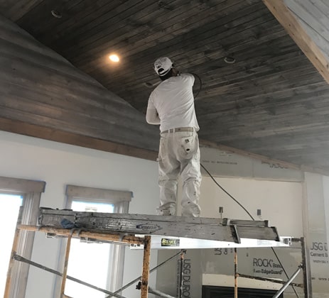 Sean Hadden Painting employee performing interior wood staining services.